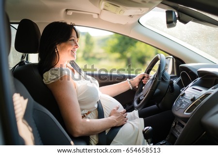 Pregnant woman driving with safety belt on in the car