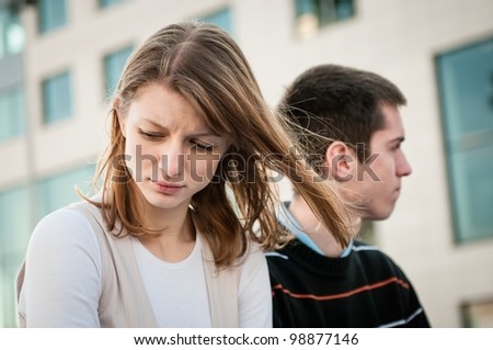 Portrait of young woman and man outdoor on street having relationship problems