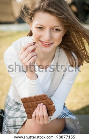 Lifestyle outdoor Young beautiful woman eating chocolate - lifestyle outdoor image