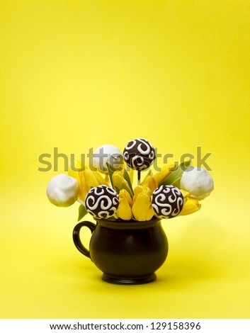 Chocolate cake pops on vibrant yellow background