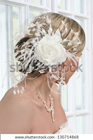 Bride with beautiful hairstyle and white hair decoration.