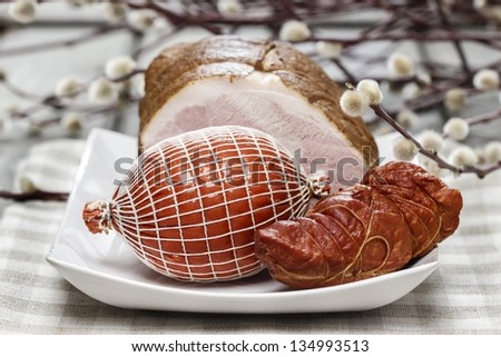 Smoked ham on squared napkin, on wooden table.