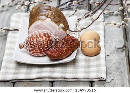 Smoked ham on squared napkin, on wooden table.