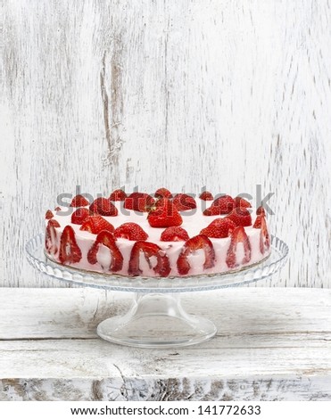 Strawberry cake on cake stand. White wooden background, copy space, selective focus.