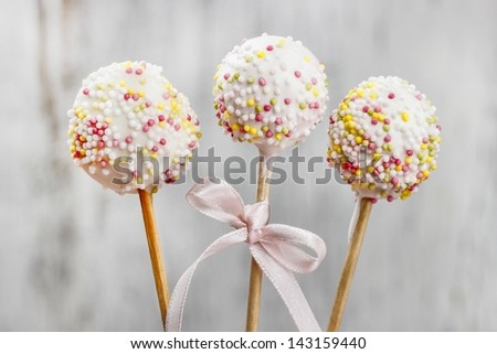 White chocolate cake pops on white wooden background