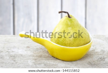 Pear in yellow ceramic plate of pear shape