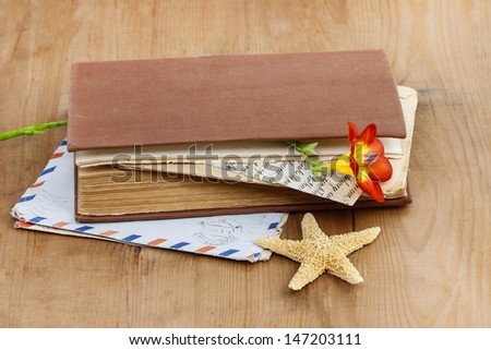 Diary, old letters and red freesia flower on wooden table. Romantic vintage setting. Copy space