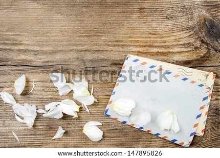 Two old letters and rose petals on wooden background. Copy space, blank surface