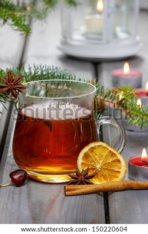 Glass of hot steaming tea among christmas decorations