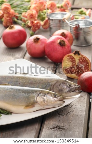 Two raw, fresh rainbow trouts among vegetables. Idea of healthy living and valuable, natural food.