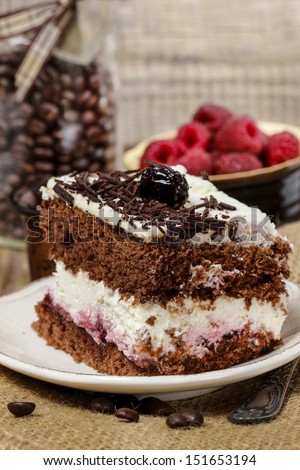 Chocolate and cherry cake. Coffee beans around, wooden background. Selective focus