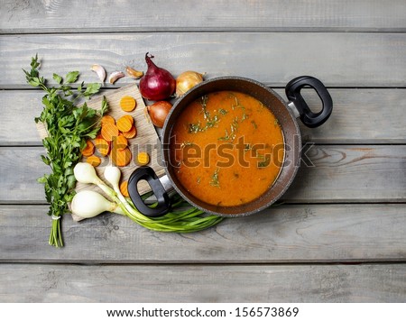 Top View On Pot Of Tomato Soup And Fresh Vegetables On Old Wooden Table
