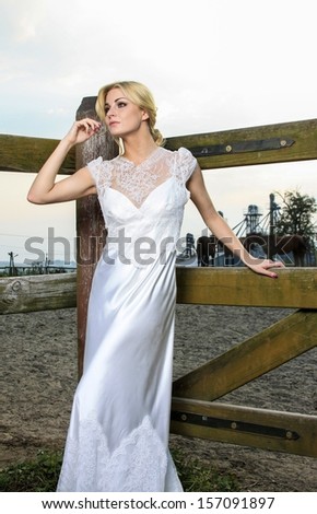Young bride, beautiful blonde, at horse ranch