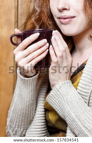 Woman holding mug of hot steaming tea in her hands. Selective focus