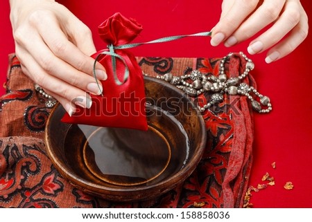 Woman opening bag with rose petals. Preparing spa hands treatment