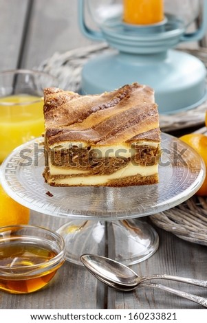 Piece of toffee and vanilla cake on transparent glass cake stand