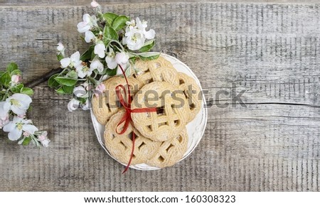 Top view of round cookies on wooden table. Apple blossom in the background. Copy space.