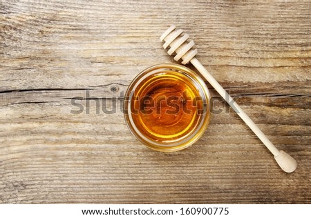 Bowl of honey on wooden table. Symbol of healthy living and natural medicine. Aromatic and tasty. Top view.