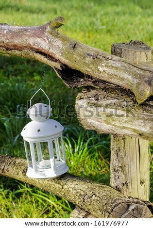 Beautiful white lantern in the garden. Sunny day, lush summer grass.