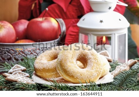 Ring sugar donuts on christmas table. Beautiful xmas setting, fir in the background