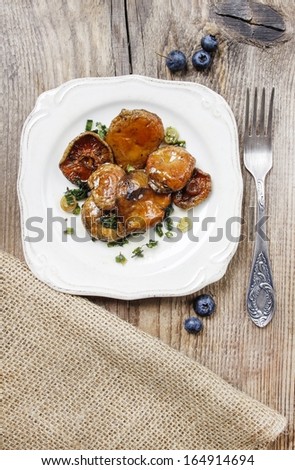 Saffron milk cap mushrooms on wooden table. Delicious autumn plate, simple recipe from popular cookbook