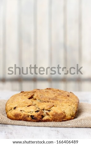 Loaf of bread on jute napkin. Wooden wall in the background. Copy space, your text here