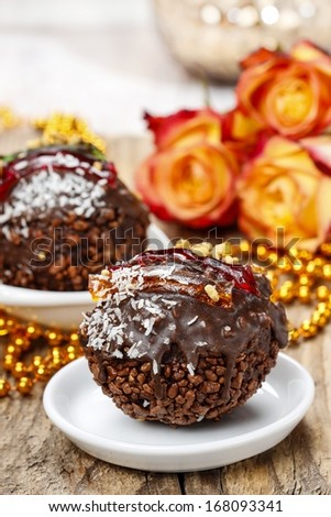 Carnival party dessert: italian round shape chocolate cake, decorated with jelly stripes, nuts and coconut.