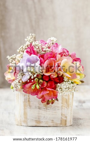 Bouquet of colorful freesia flowers in wooden shabby chic box. Copy space
