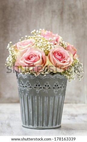 Bouquet of pink roses in rustic bucket