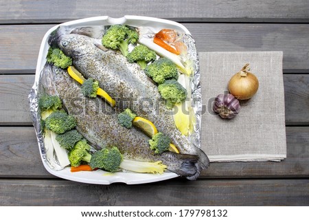 Healthy dinner: trouts and vegetables. Wooden table, top view