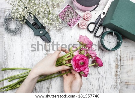 Florist at work. Woman making beautiful bouquet of pink persian buttercup flowers (ranunculus asiaticus)