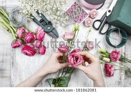 Florist at work. Woman making beautiful bouquet of pink eustoma flowers