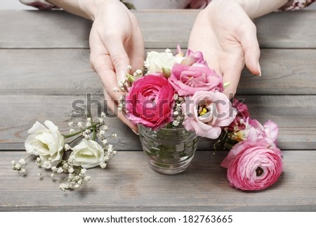 Woman making floral wedding decorations. Tiny bouquet of beautiful pink flowers