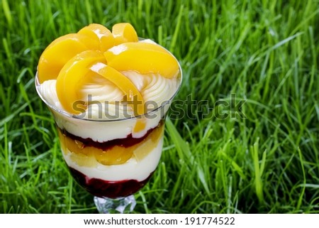 Layer peach and strawberry dessert with whipped cream topping