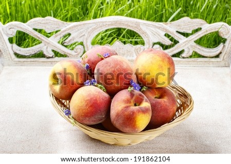 Basket of peaches on wooden tray. Summer garden party idea
