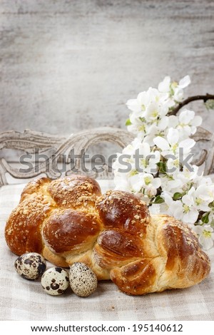 Loaf of sweet bread and apple blossom twig in the background