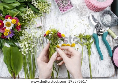 Florist at work. Woman making bouquet of wild flowers