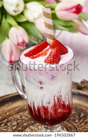 Strawberry milkshake, beautiful bouquet of pink and white tulips in the background