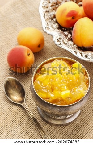 Bowl of apricot jam and ripe apricots in the background