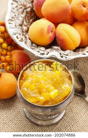 Bowl of apricot jam and ripe apricots in the background