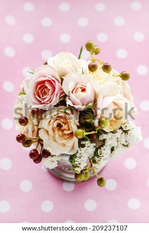 Bouquet of pastel pink and peach roses on pink dotted background