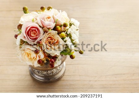 Bouquet of pastel pink and peach roses on wooden background. Copy space