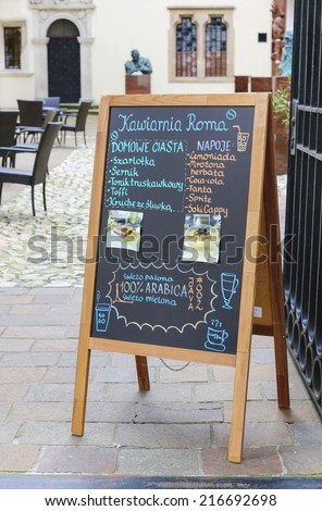 KRAKOW, POLAND - SEPTEMBER 12, 2014: Street menu board of famous Roma Cafe, Krakow, Poland