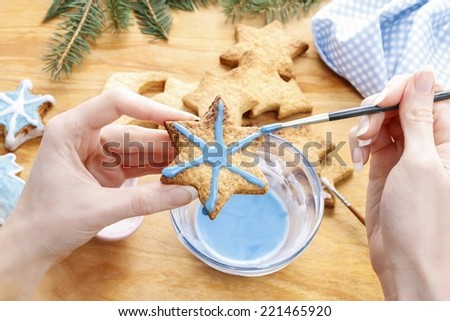 Decorating gingerbread cookies with blue and white icing. Steps of making biscuits