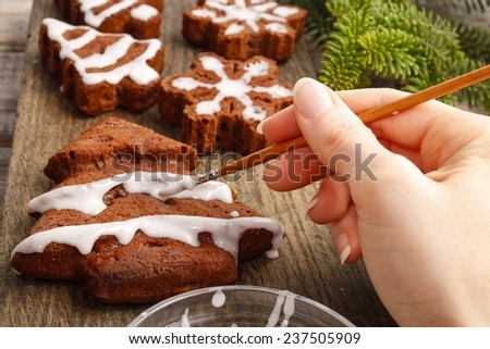 Decorating christmas gingerbread chocolate cookies with white icing