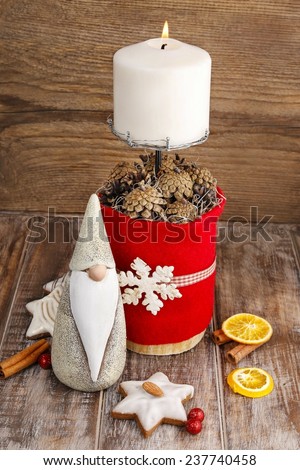 Christmas decorations - white candle on handmade red candle holder decorated with wooden snowflake and cones