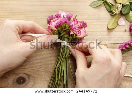 Steps of making wrist corsage. Florist at work. Woman making beautiful bouquet of pink roses.