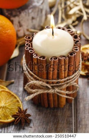 Candle decorated with cinnamon sticks, christmas decoration