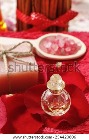 Spa set: bottle of perfume, sea salt, bar of soap and romantic red rose petals