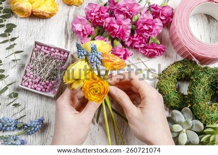Florist at work. Woman making bouquet of ranunculus flowers